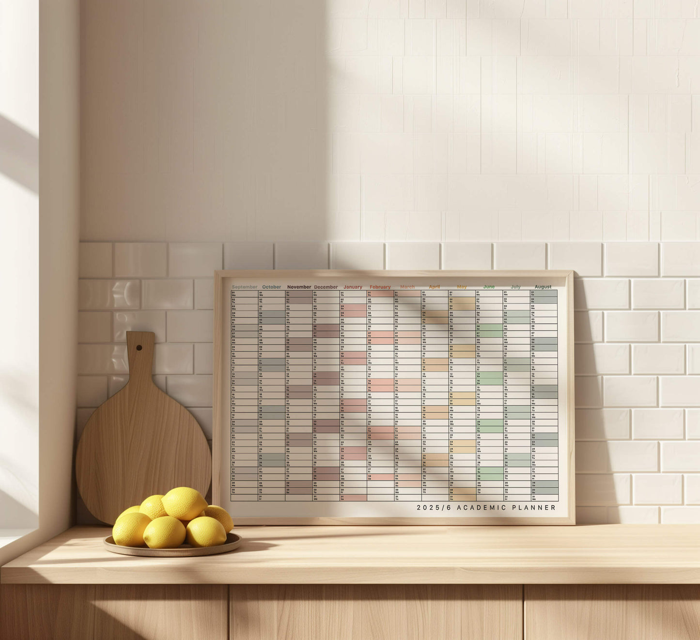 Framed academic planner on a wooden shelf with lemons and a cutting board.
