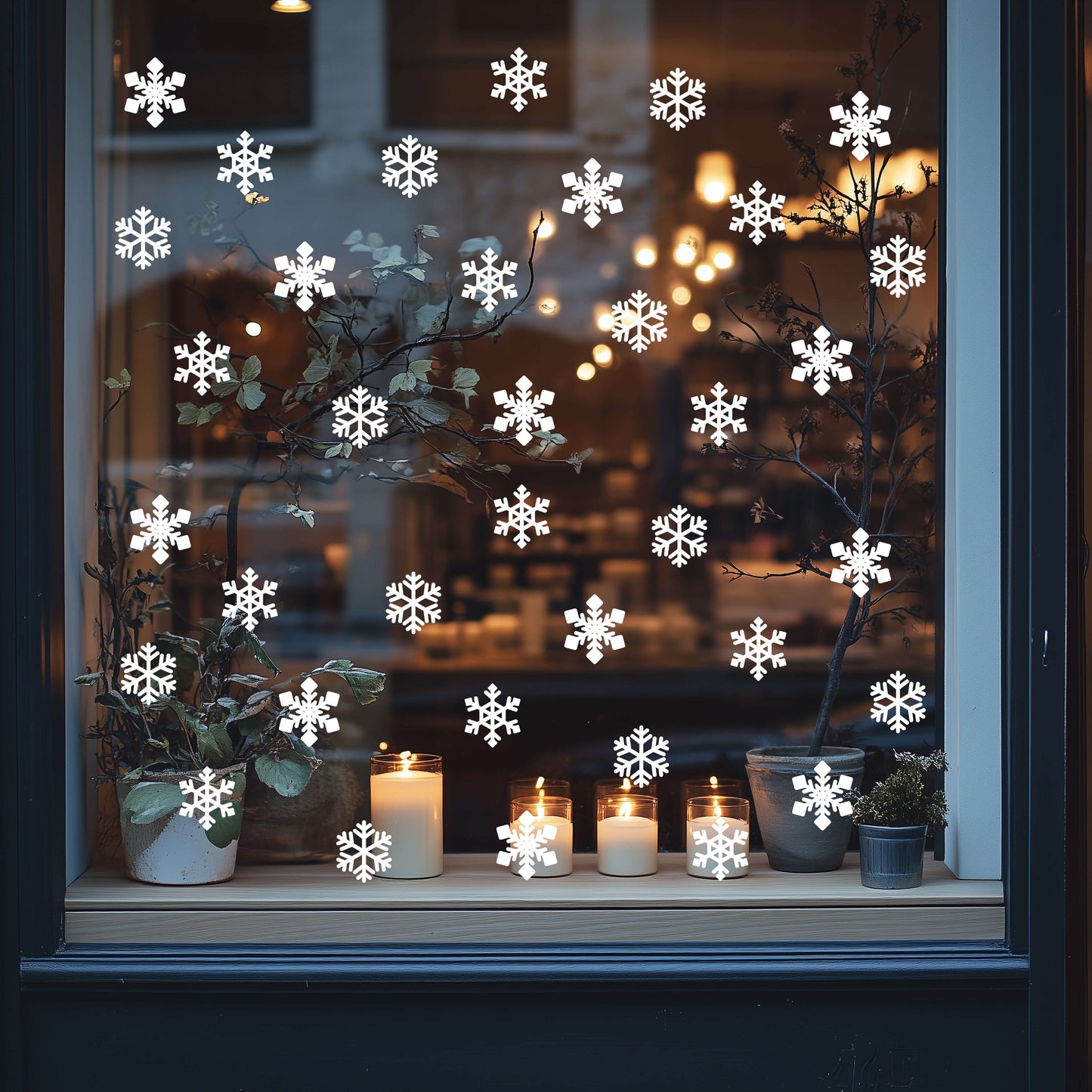 Decorative festive window with snowflake stickers, candles, and plants.