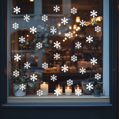 Decorative festive window with snowflake stickers, candles, and plants.