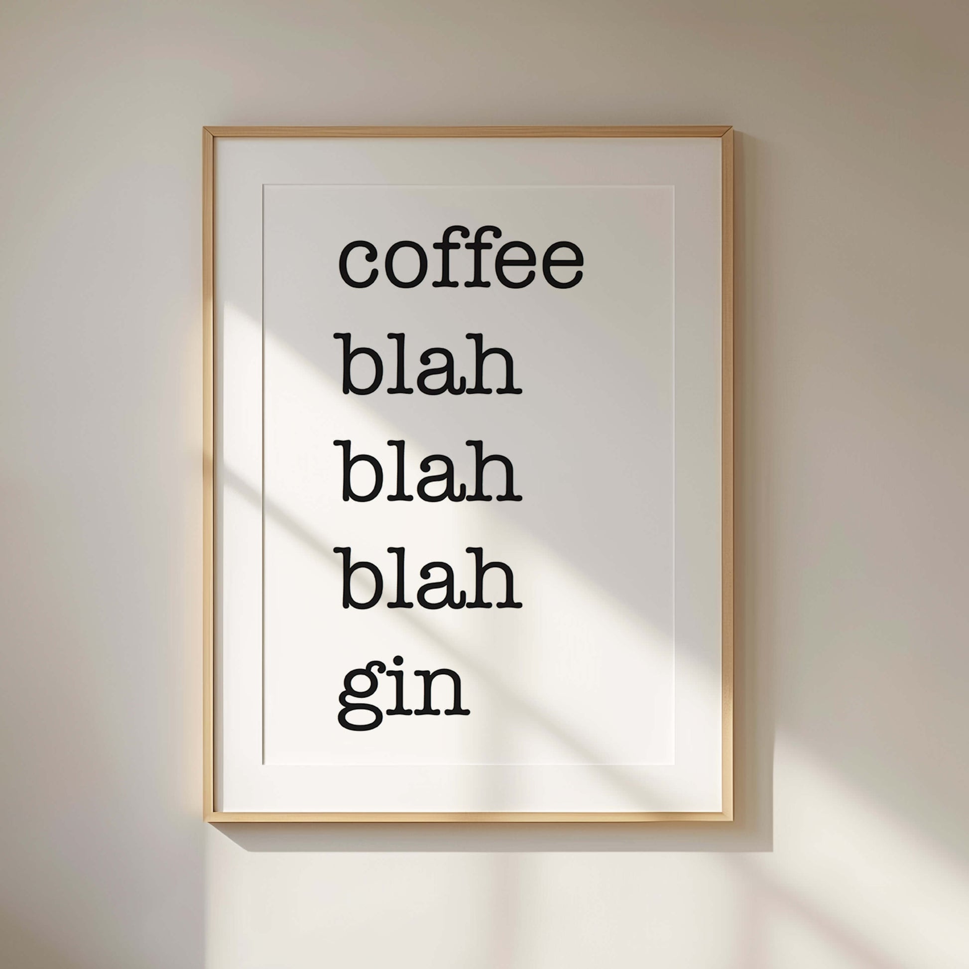 Framed print with text 'coffee blah blah blah gin' on a beige wall