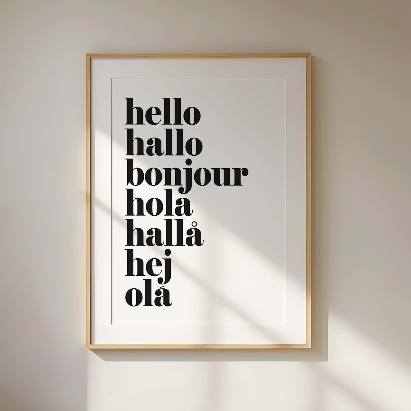 Framed poster with hello in European languages typography on a wall.