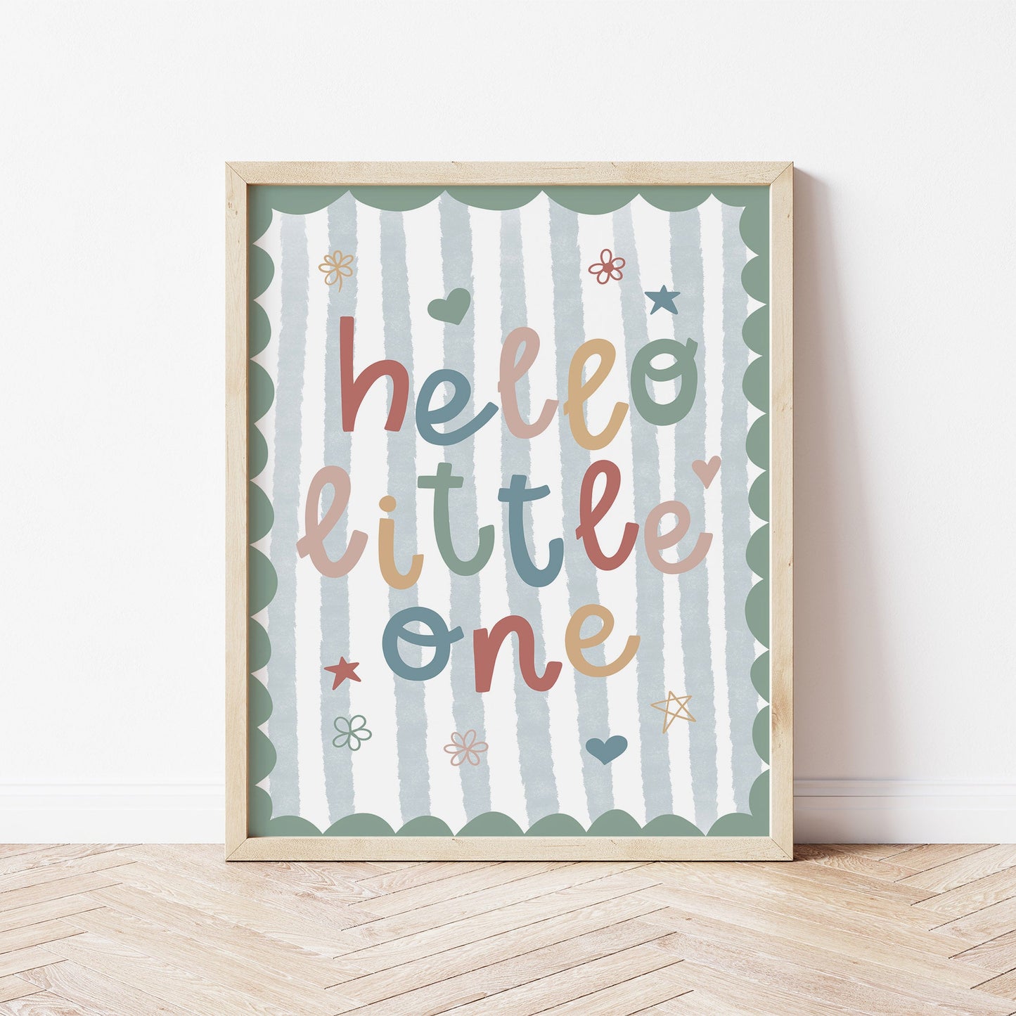 Framed nursery artwork with 'hello little one' text on a striped background for boys bedroom.