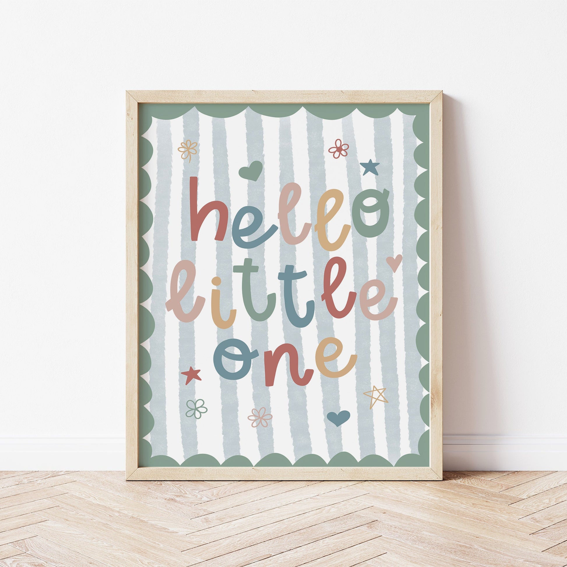 Framed nursery artwork with 'hello little one' text on a striped background for boys bedroom.
