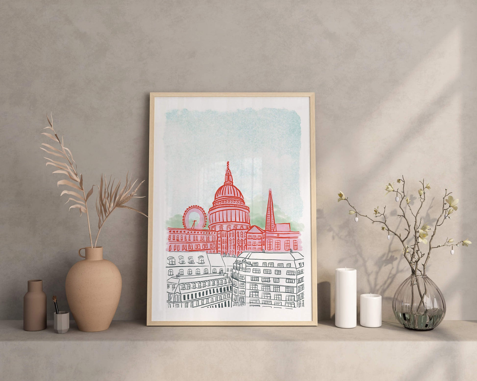 Framed artwork of a cityscape with a red building on a shelf against a gray wall.