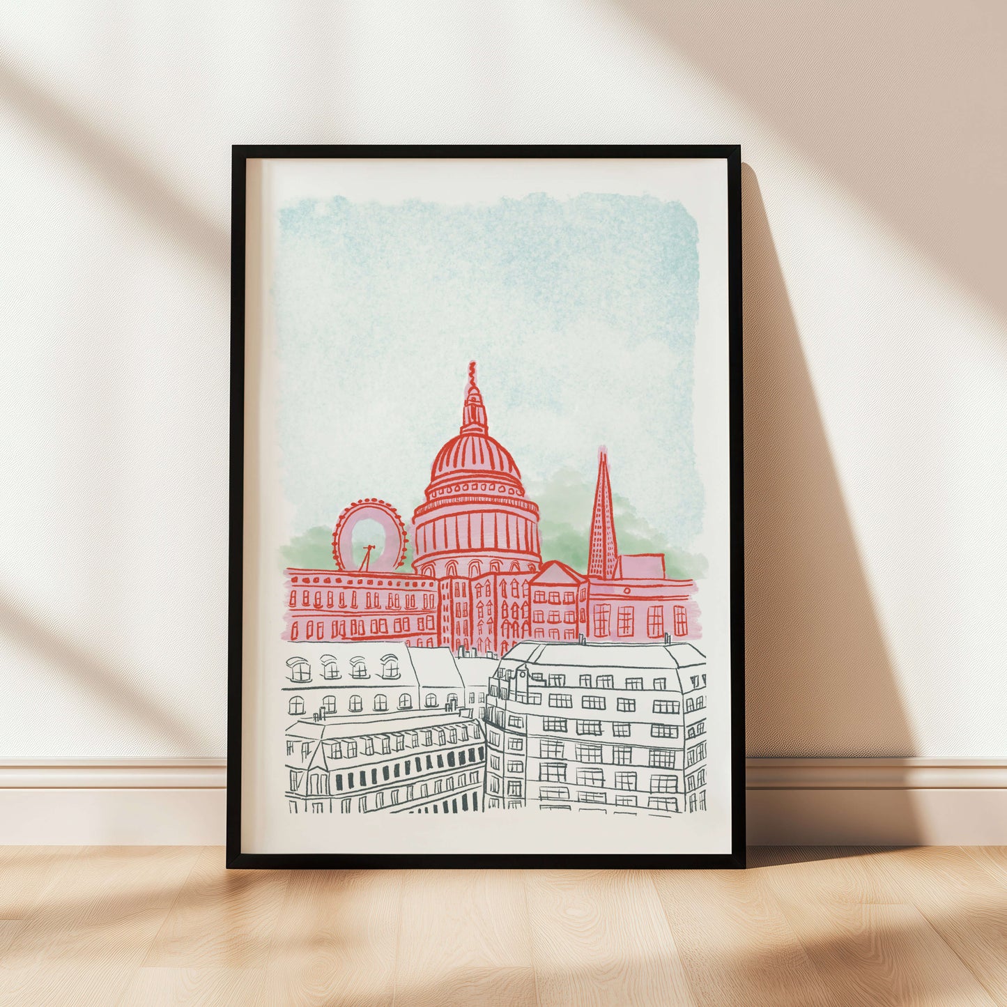 Framed artwork of a cityscape with a prominent building on a white wall.