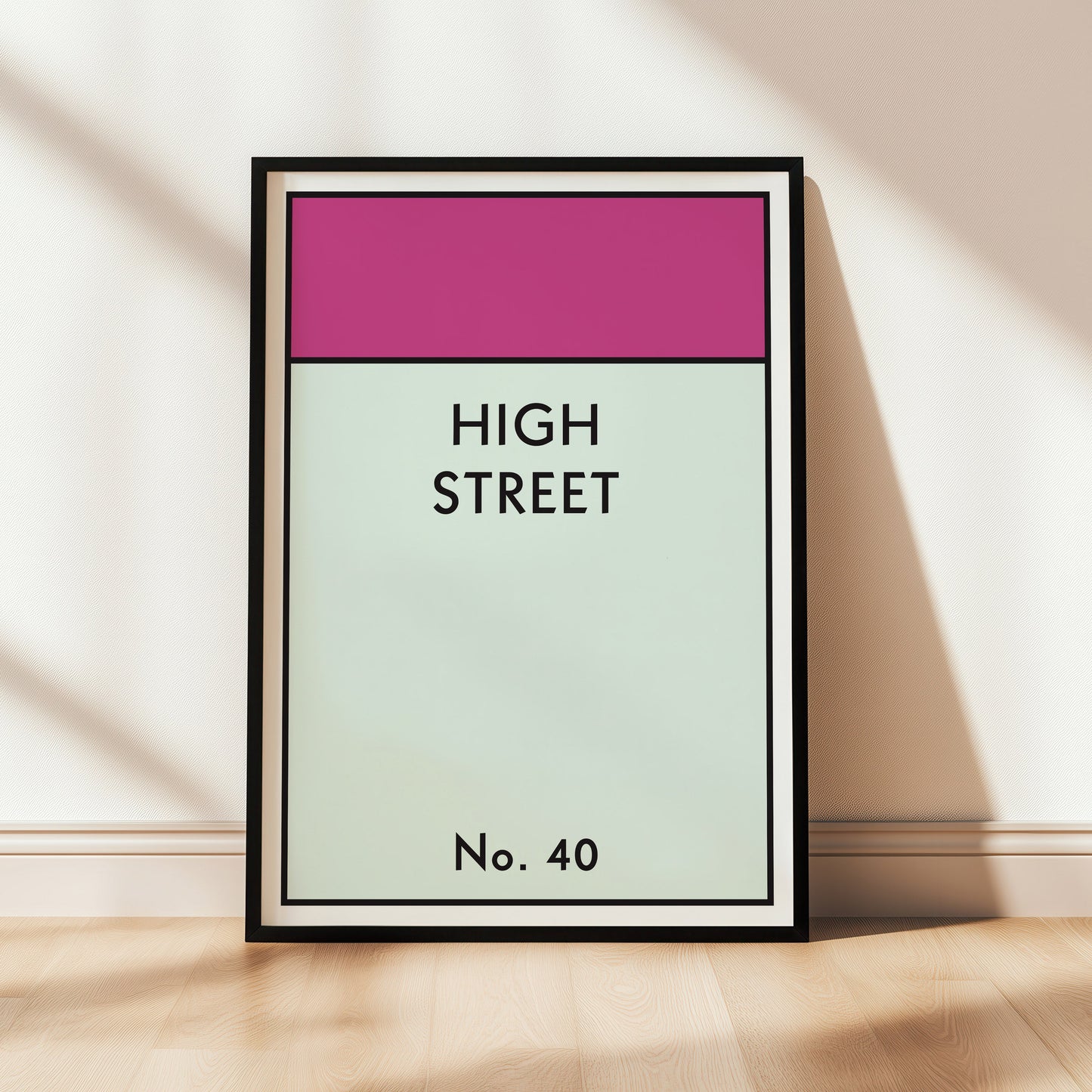 Customised framed monopoly style artwork with 'HIGH STREET No. 40' text on a white wall.