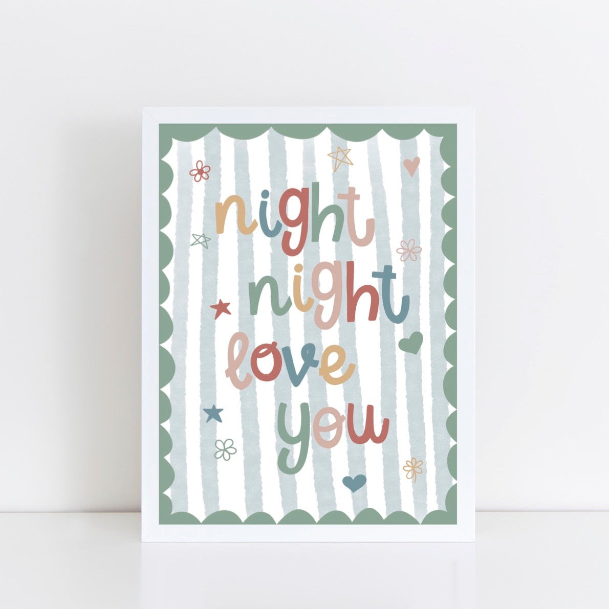 White framed children's nursery wall art with 'night night love you' text on a blue striped background with a green scalloped edge.