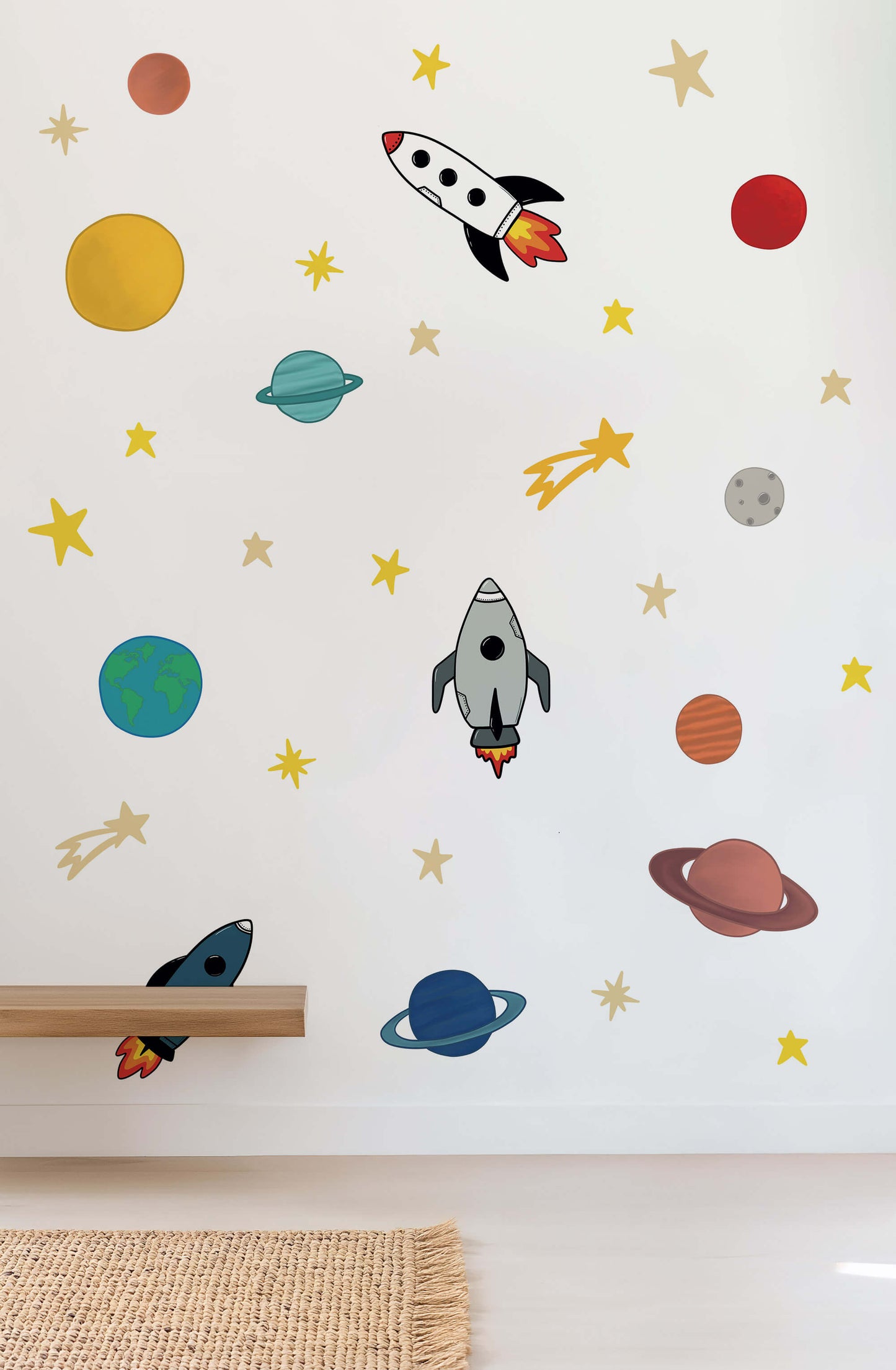 Wall with space-themed wall stickers including rockets, planets, and stars on a white background.