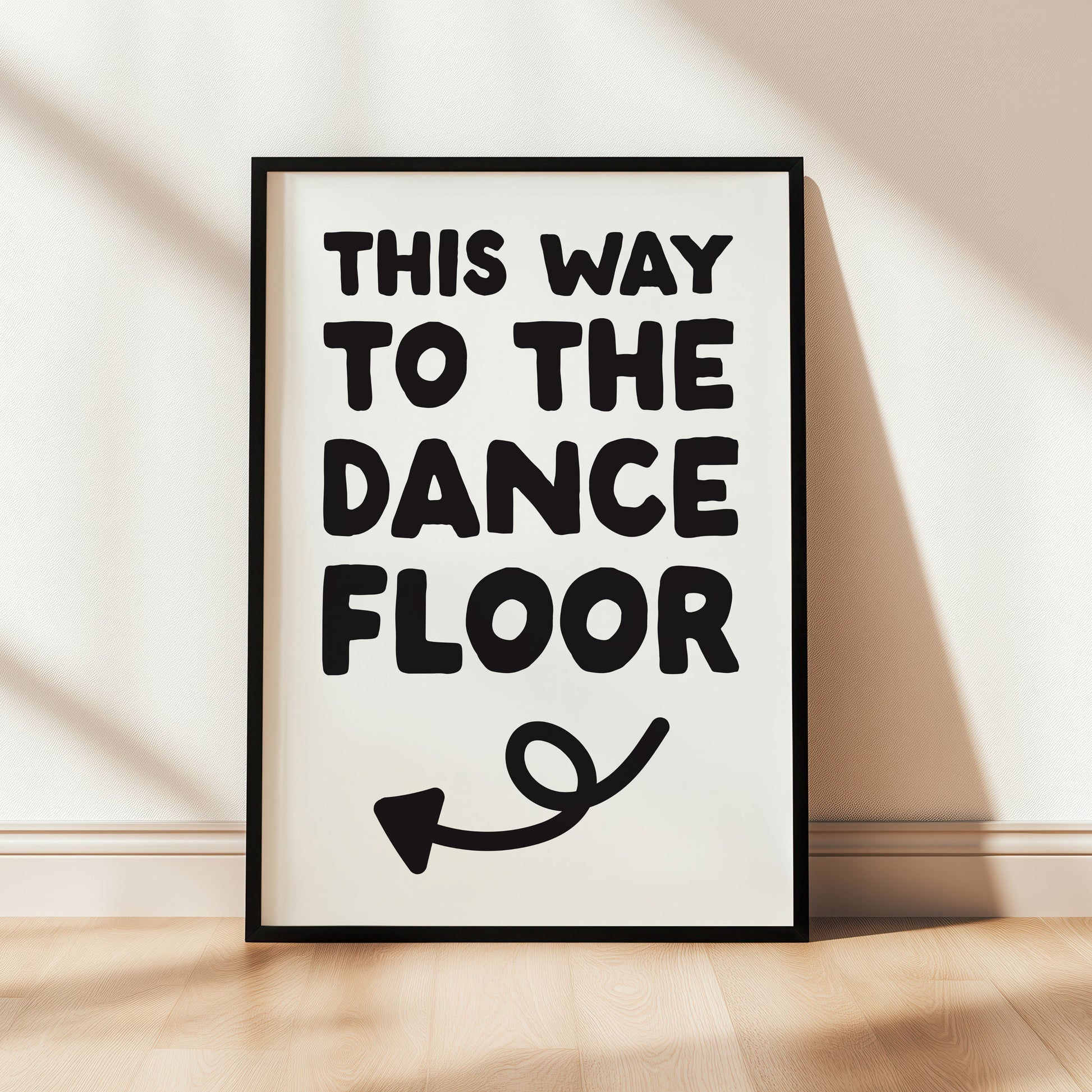 Framed poster with 'This Way to the Dance Floor' text on a wall.